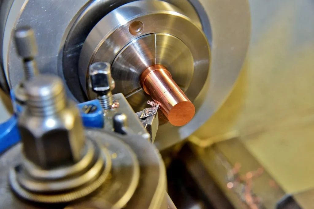 Hydraulic Broaching Machining Guide:Secrets for 50% Faster 5 Metal cutting on a machine tool with chips peeling from a copper workpiece, illustrating the hydraulic broaching machining guide